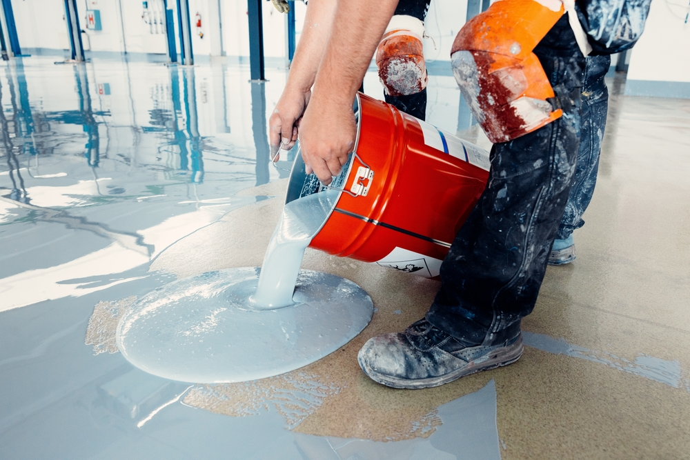 construction,workers,applying,epoxy,flooring,system,with,a,self leveling,epoxy
